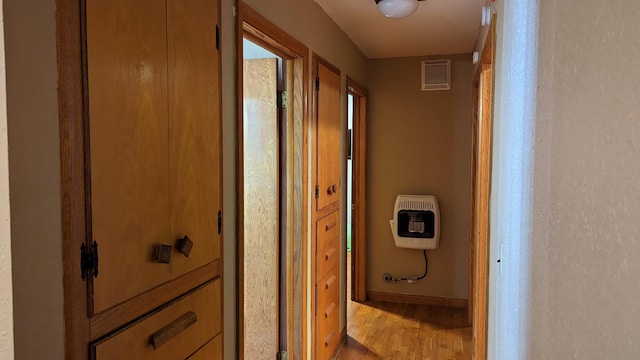 hallway featuring wood-type flooring and heating unit