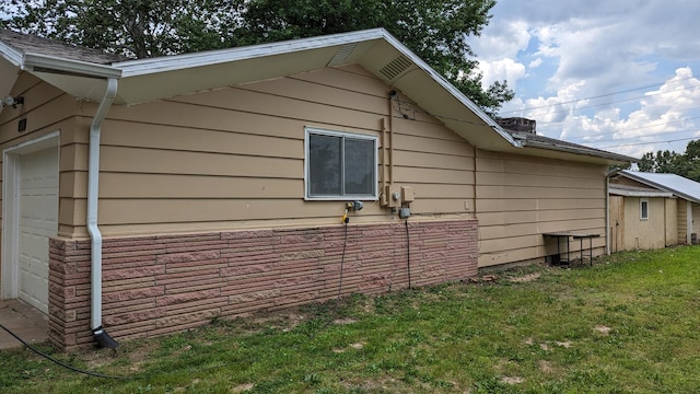 view of property exterior with a garage and a yard