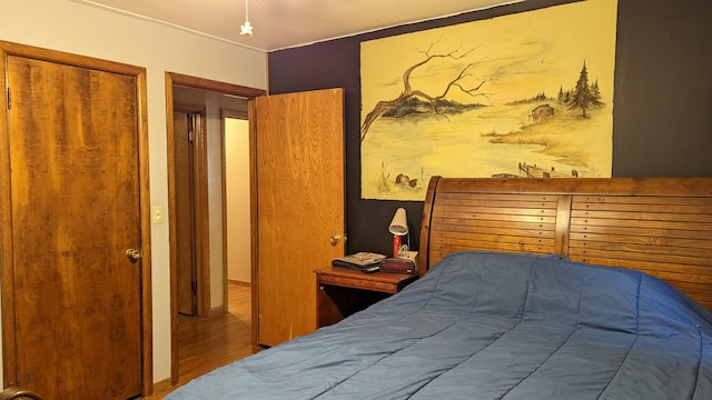 bedroom featuring hardwood / wood-style flooring, crown molding, and a closet