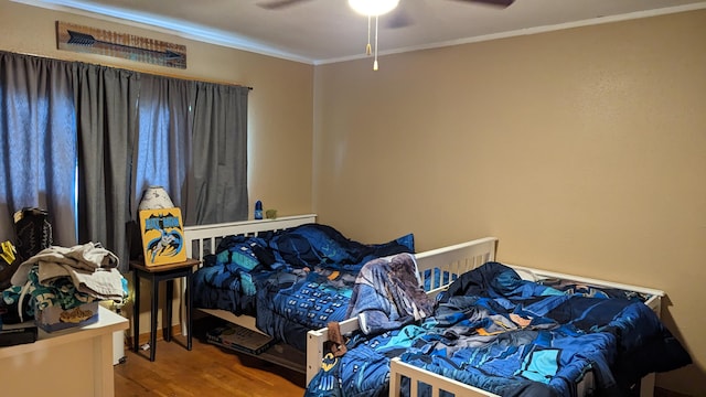 bedroom featuring ceiling fan, hardwood / wood-style flooring, and ornamental molding