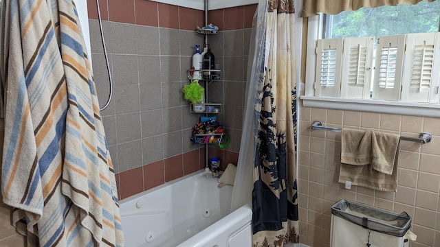 bathroom featuring tile walls and shower / bath combo