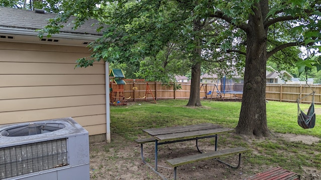 view of yard with a trampoline and central air condition unit