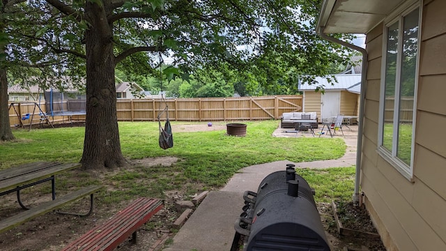 view of yard featuring a trampoline and a patio