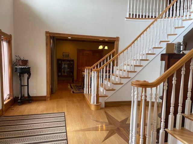 foyer entrance featuring hardwood / wood-style flooring and a towering ceiling