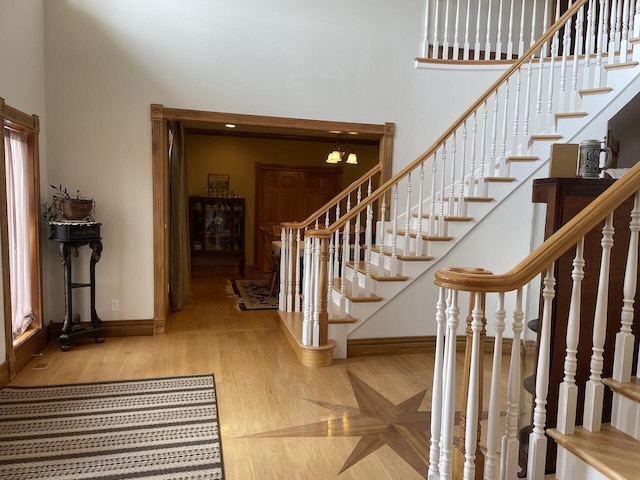 1179 County Road 1050, Willow Springs, MO 65793 - staircase with baseboards, wood finished floors, a high ceiling, and an inviting chandelier