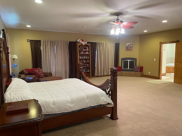 bedroom with light carpet, ensuite bath, and ceiling fan