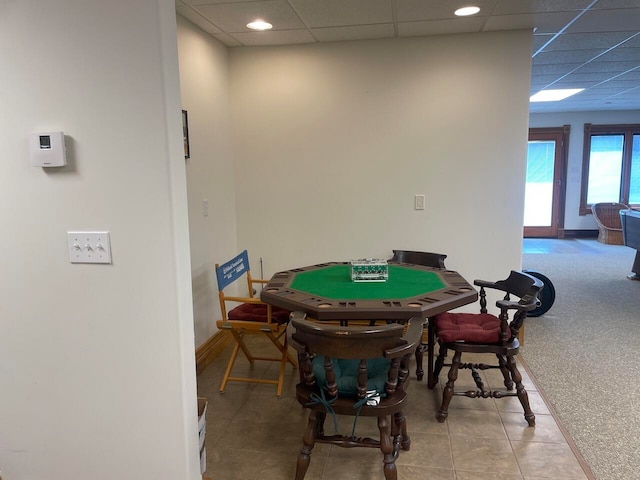 rec room featuring light tile patterned flooring and a drop ceiling