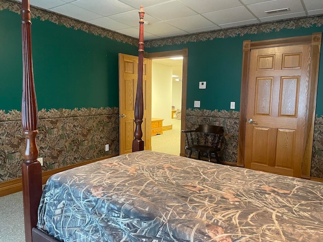 carpeted bedroom with a drop ceiling