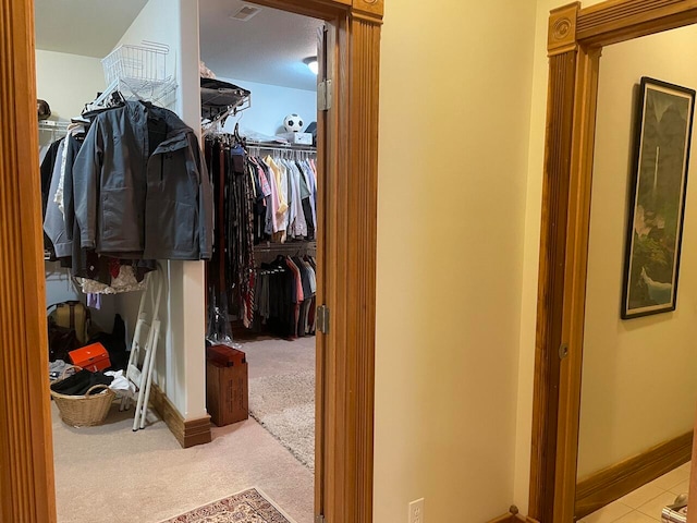 walk in closet featuring light colored carpet