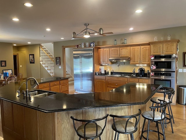 1179 County Road 1050, Willow Springs, MO 65793 - kitchen featuring under cabinet range hood, a sink, a kitchen bar, and appliances with stainless steel finishes