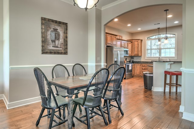 dining area featuring light hardwood / wood-style floors and ornamental molding