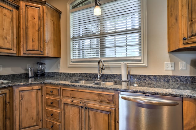 kitchen with dark stone counters, sink, and stainless steel dishwasher