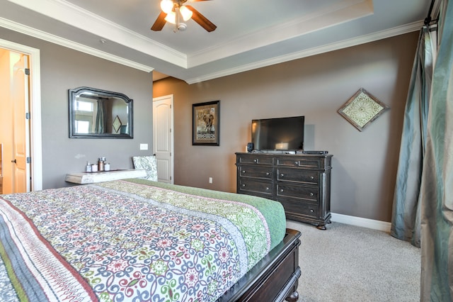 carpeted bedroom featuring ceiling fan, a tray ceiling, and crown molding