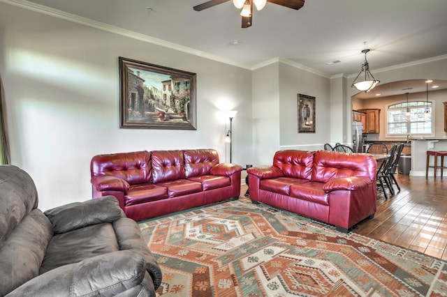 living room featuring dark wood-type flooring, crown molding, and ceiling fan