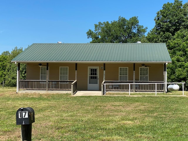 view of front of property featuring ceiling fan, a front lawn, and covered porch