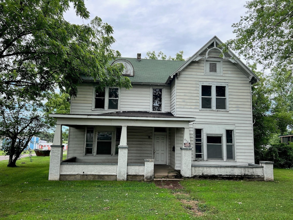 view of front of property with a porch and a front lawn