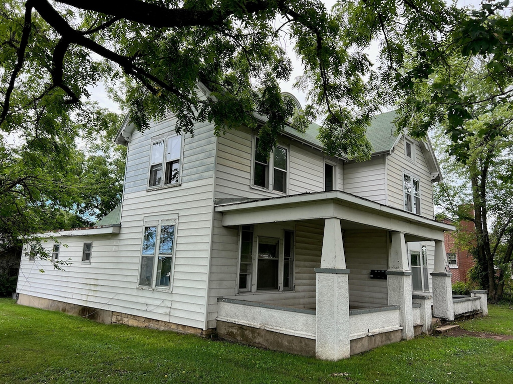 exterior space with covered porch and a lawn