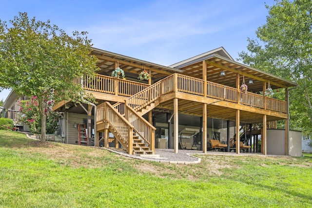 rear view of property featuring a wooden deck, stairway, and a yard