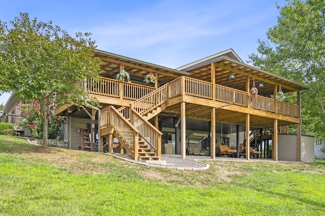 back of house with a lawn, a wooden deck, a carport, and stairs