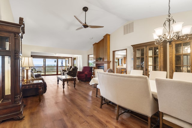 living area with high vaulted ceiling, dark wood-style floors, visible vents, and ceiling fan with notable chandelier