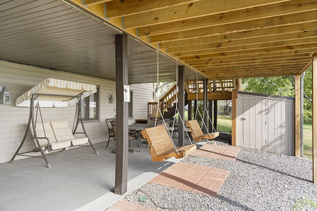 view of patio / terrace with a storage shed, outdoor dining space, an outbuilding, and stairs