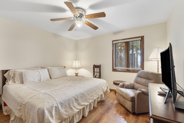 bedroom with wood finished floors, a ceiling fan, and baseboards
