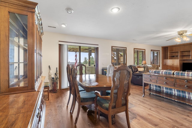 dining area with light hardwood / wood-style floors and ceiling fan