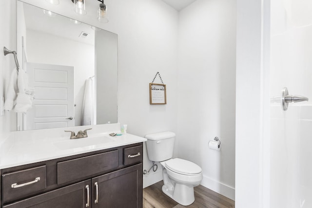 bathroom featuring vanity, hardwood / wood-style floors, toilet, and curtained shower