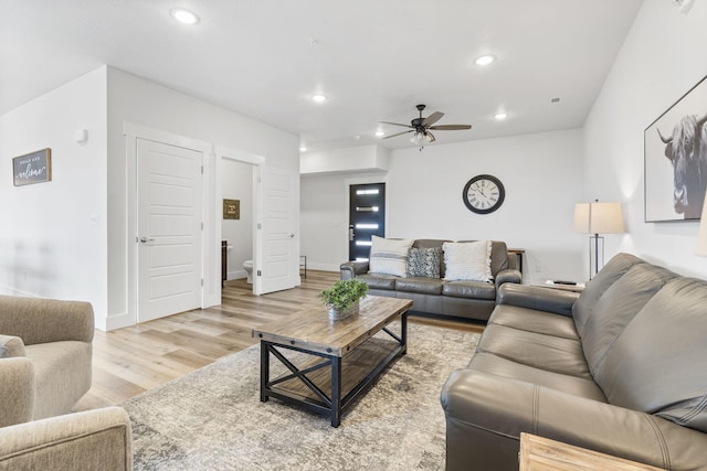 living room with light wood-type flooring and ceiling fan