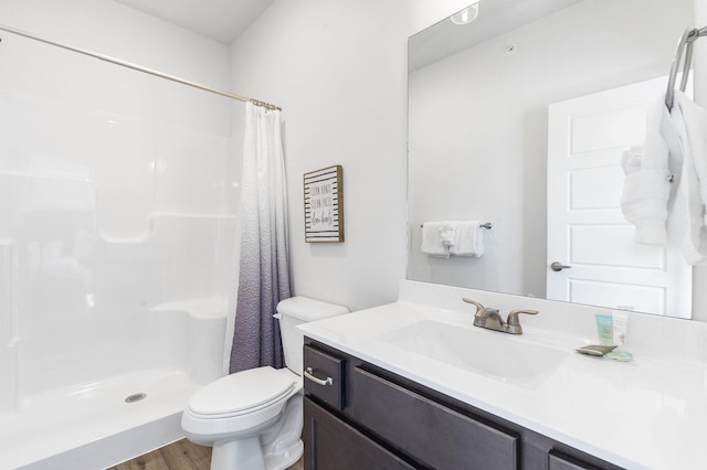 bathroom with curtained shower, hardwood / wood-style floors, vanity, and toilet