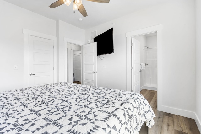 bedroom featuring ceiling fan, ensuite bath, and hardwood / wood-style floors