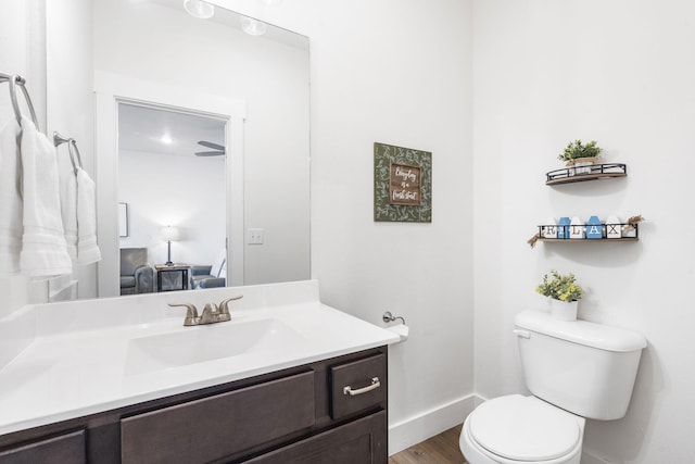 bathroom with wood-type flooring, vanity, and toilet