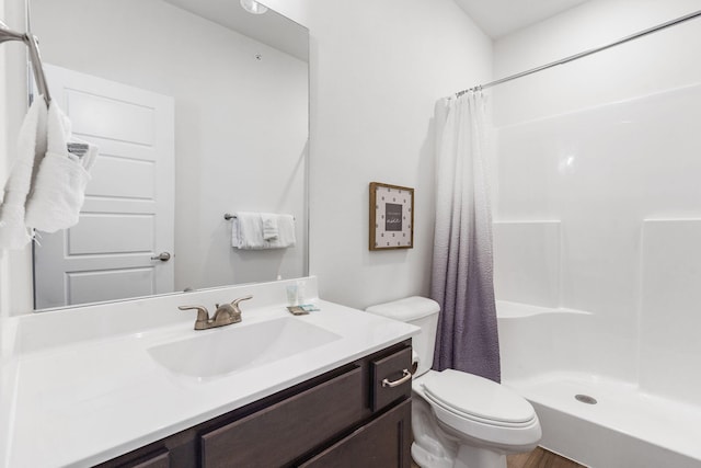 bathroom with hardwood / wood-style floors, toilet, a shower with curtain, and vanity