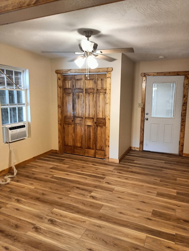 unfurnished dining area with wood-type flooring, cooling unit, a textured ceiling, and ceiling fan