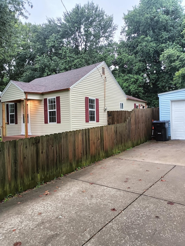 view of home's exterior featuring concrete driveway, fence, and a garage