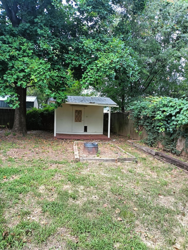 view of yard featuring fence, an outbuilding, and a shed