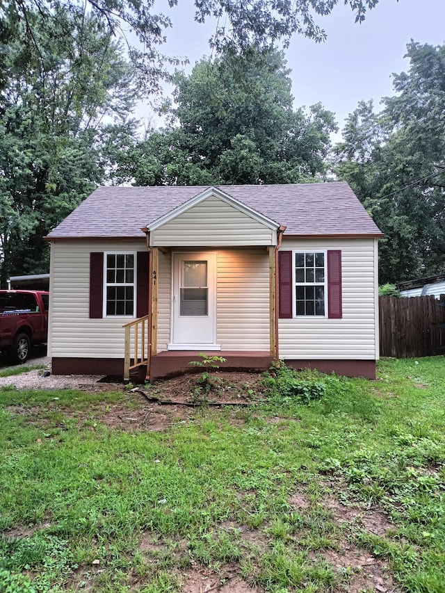 view of front of home featuring a front lawn and fence