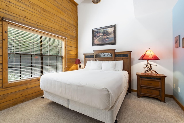 bedroom with wood walls and light colored carpet