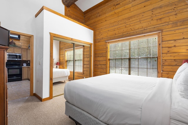 carpeted bedroom featuring high vaulted ceiling, wooden walls, and a closet