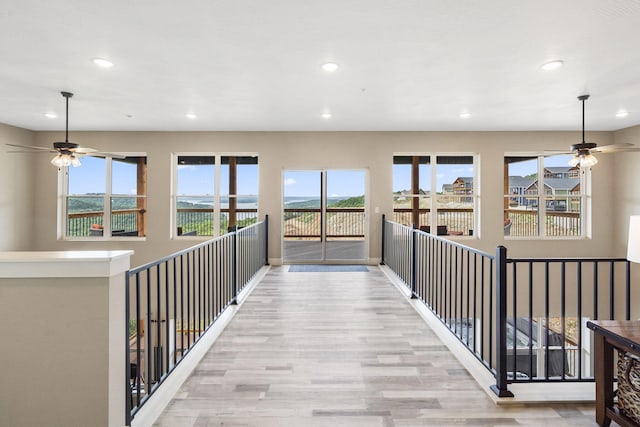 hallway with recessed lighting, wood finished floors, and plenty of natural light