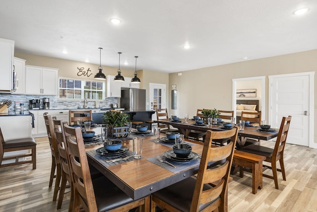 dining space featuring sink and light wood-type flooring