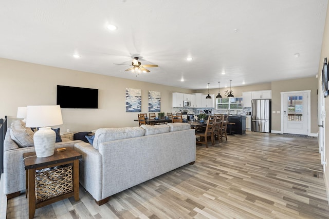 living room featuring light hardwood / wood-style flooring and ceiling fan