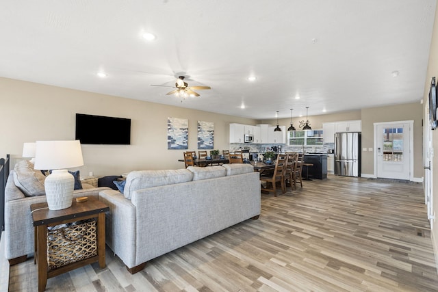 living area featuring recessed lighting, light wood-style flooring, visible vents, and a ceiling fan