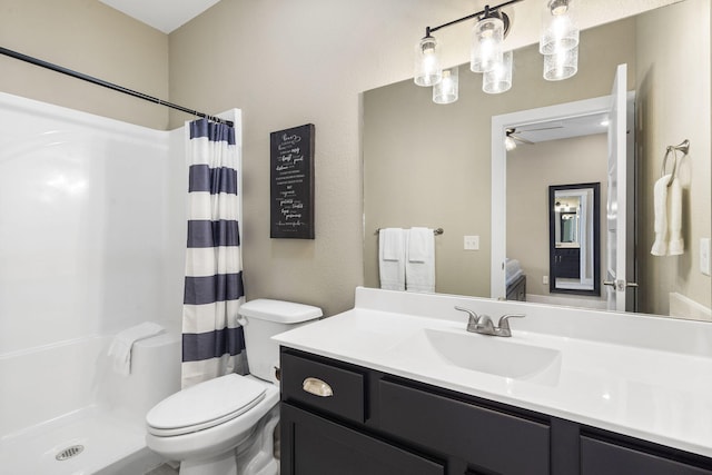 bathroom featuring walk in shower, vanity, toilet, and ceiling fan