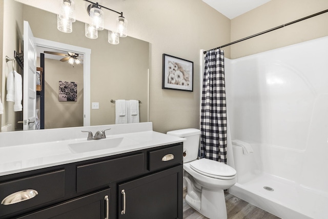 bathroom featuring ceiling fan, toilet, hardwood / wood-style floors, a shower with shower curtain, and vanity