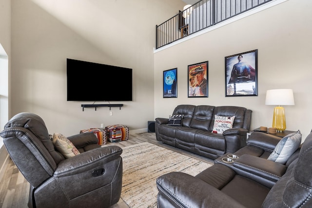 living room with hardwood / wood-style flooring and a towering ceiling