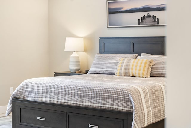 bedroom with baseboards and wood finished floors