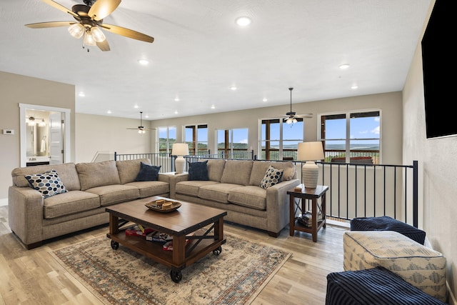 living room with a ceiling fan, recessed lighting, and light wood-style flooring
