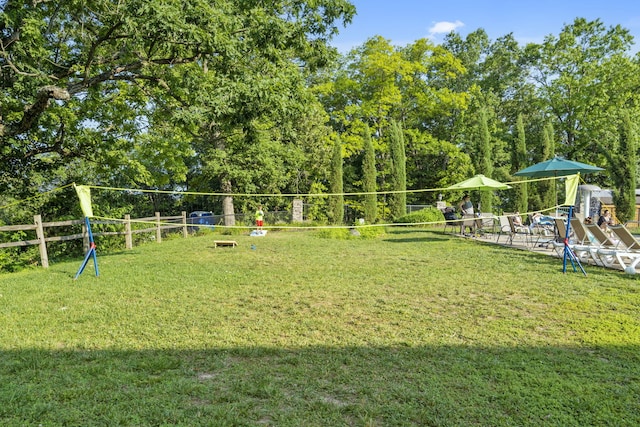 surrounding community with a lawn, a playground, and fence