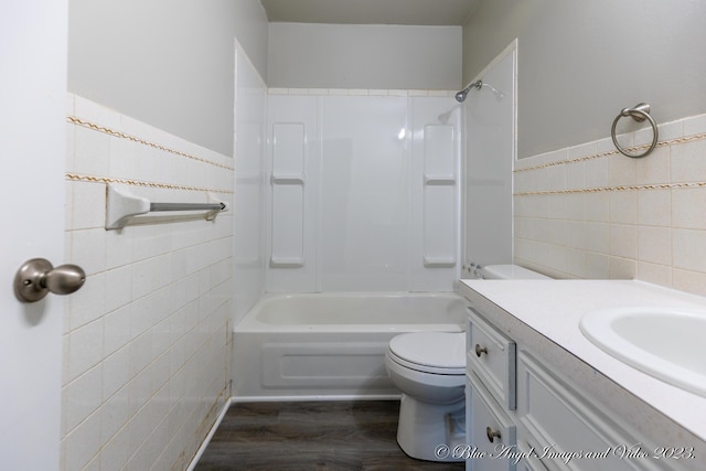 bathroom featuring tile walls, wood finished floors, vanity, and toilet